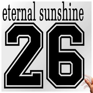 Pode incluir: Um autocolante a preto e branco com as palavras "eternal sunshine" acima do número "26". Os números estão numa fonte a negrito, em estilo universitário, com uma contorno branco. Fundo branco.