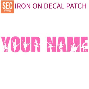 May include: Pink iron-on decal patch with the words "YOUR NAME" spelled out using silhouette images of ballerinas.
