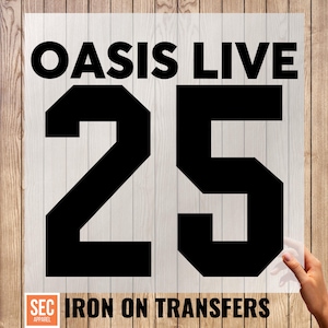 Może przedstawiać: Czarny transfer do naprasowywania z napisem "OASIS LIVE 25". Numer 25 jest duży i pogrubiony. Tekst "IRON ON TRANSFERS" znajduje się na dole, wraz z logo "SEC APPAREL". Tło to jasny wzór słojów drewna.