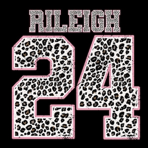 May include: A black background with the name "RILEIGH" in leopard print lettering above the number "24". The number "24" is in a leopard print pattern with a pink outline.