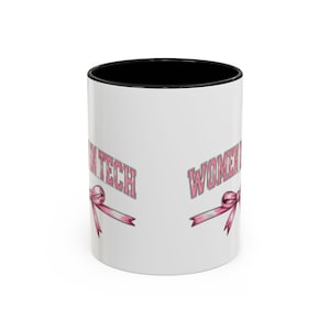 Peut inclure: Mug en céramique blanche avec intérieur noir. Le mug présente le texte "WOMEN IN TECH" en rose, ainsi qu'un ruban rose. Le mug est conçu pour les boissons chaudes ou froides.