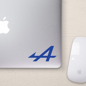 May include: A silver laptop with a blue "A4" sticker on the back. The laptop has a white Apple logo on the lid.