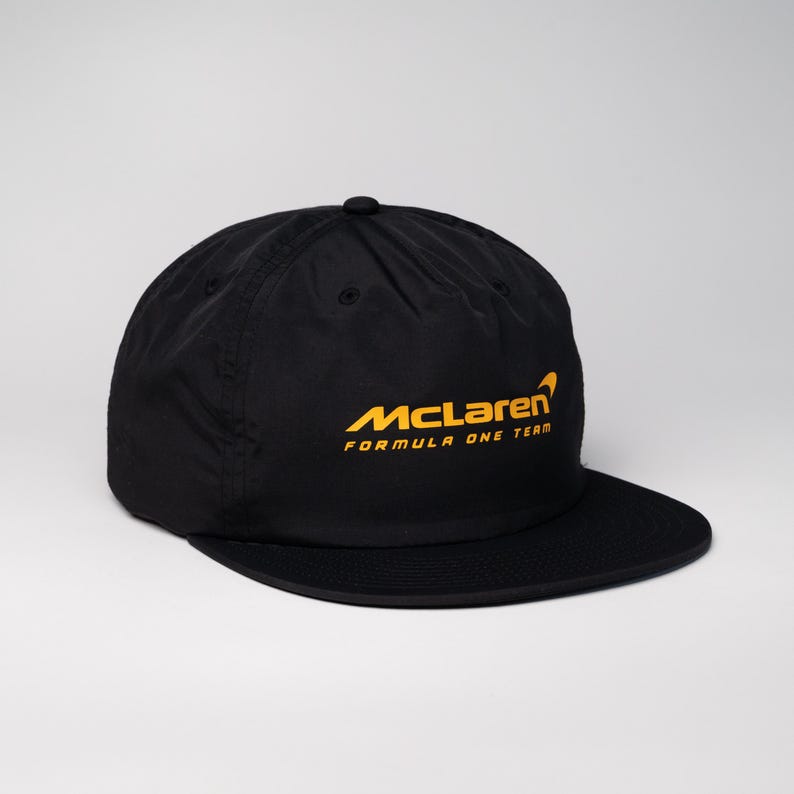 May include: Black baseball cap with a yellow McLaren Formula One Team logo.