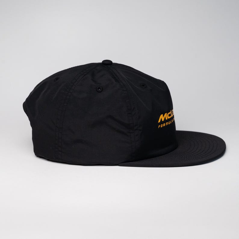 May include: A black baseball cap with a yellow embroidered logo that reads "McLaren Formula 1".
