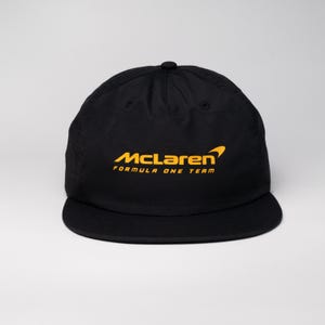 May include: Black baseball cap with a yellow McLaren Formula One Team logo.