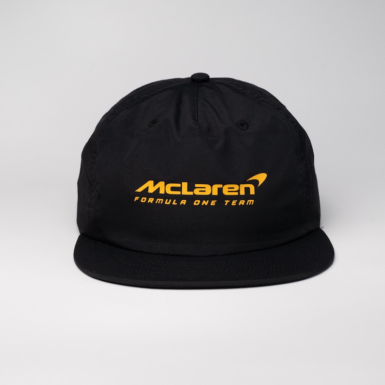 May include: Black baseball cap with a yellow McLaren Formula One Team logo.