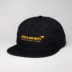 Pode incluir: Boné de beisebol preto com um logotipo amarelo da McLaren Formula One Team.