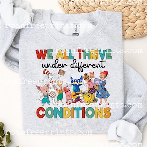 Puede incluir: Una sudadera gris claro con el texto "WE ALL THRIVE under different CONDITIONS" en letras coloridas. El gráfico presenta personajes de dibujos animados, incluyendo el Gato en el Sombrero, Pete el Gato, y otros.