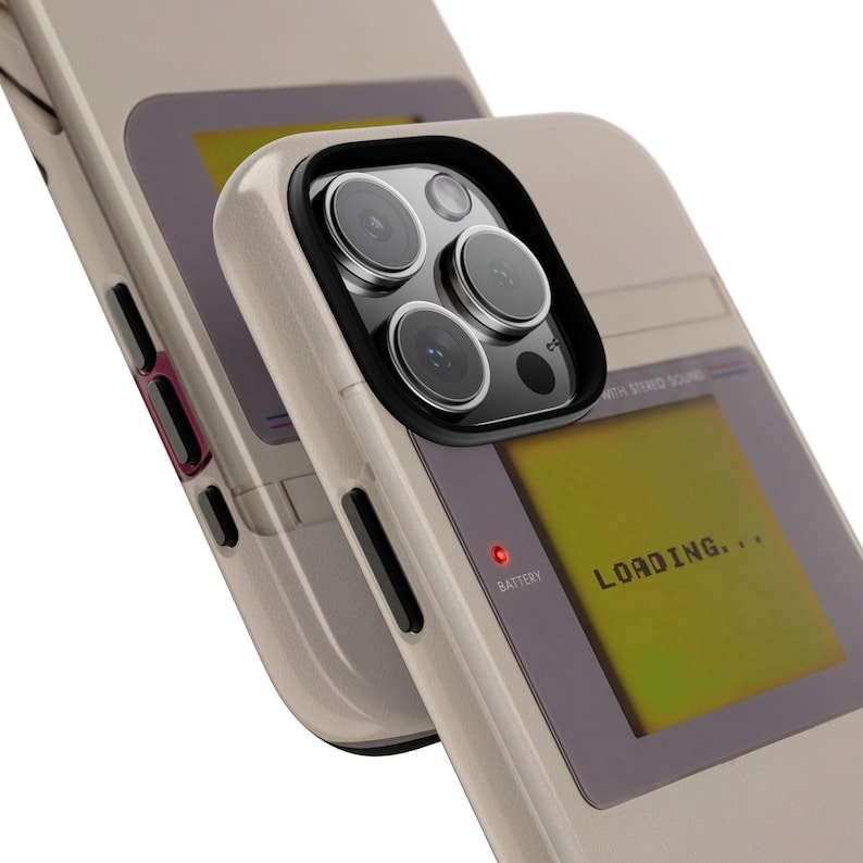 May include: Beige phone case with a retro video game design. The case features a screen displaying "LOADING..." and a red battery indicator. The camera lenses are visible, and the case has black accents.