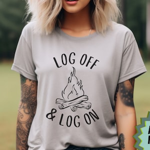 May include: A gray t-shirt with the text "Log Off & Log On" and a campfire graphic. The shirt is made of athletic heather fabric.