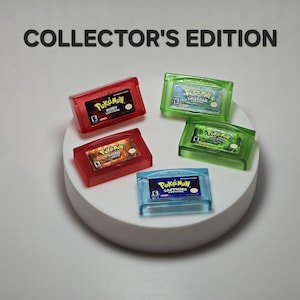 May include: A collection of five translucent Game Boy Advance cartridges labeled COLLECTOR'S EDITION. The set includes red Ruby and FireRed versions, green Emerald and LeafGreen versions, and a blue Sapphire version, all featuring Pok&eacute;mon branding.