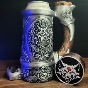 May include: A silver metal beer stein with a wolf design and a matching lid. The stein has a built-in tray for holding dice and a separate lid with a wolf design.