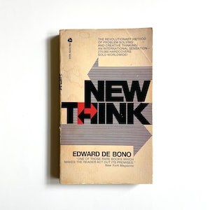 May include: Vintage paperback book titled "New Think" by Edward De Bono. The cover features the title in bold black letters with a red arrow, set against a beige background with blue and white stripes. The book's cover also includes text about problem-solving.