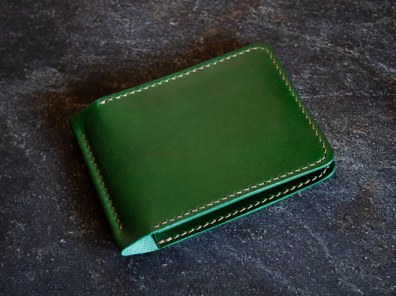 May include: A green leather wallet with a stitched edge.