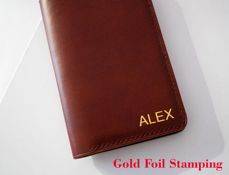 May include: A brown leather notebook with gold foil stamping that reads "ALEX".