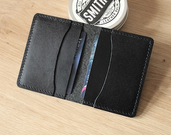 May include: A black leather wallet with multiple card slots and a stitched edge.