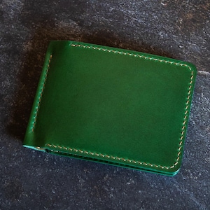 May include: A green leather wallet with a stitched edge.