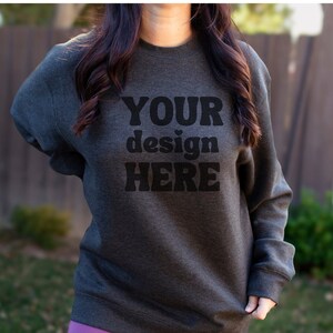 May include: A dark gray sweatshirt with the text "YOUR design HERE" printed in black.