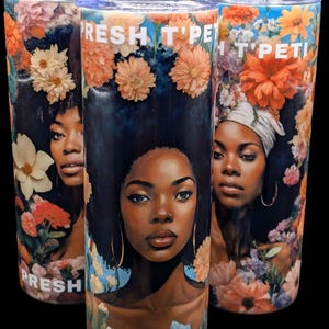 May include: Three stainless steel tumblers with a floral design and a black woman's face in the center. The tumblers have the text "Fresh T'Pet" on the top.