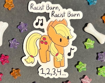 May include: A sticker featuring a cartoon pony with a blonde mane and tail, red apple markings, and musical notes. The text "Racist Barn" and "1,2,3,4..." are also present. The sticker is surrounded by colorful star-shaped beads and a bone-shaped bead.