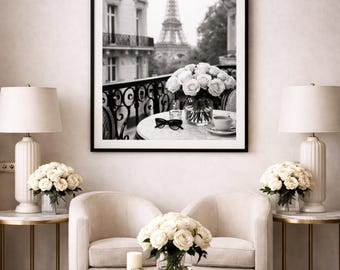 May include: A black and white framed print of the Eiffel Tower in Paris, France, hangs above a cream-colored loveseat. The room is decorated with white roses, lamps, and gold accents, creating a luxurious and elegant atmosphere.