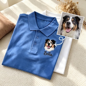 Könnte beinhalten: Ein blaues Poloshirt mit einer Knopfleiste mit drei Knöpfen und einem gestickten Porträt eines dreifarbigen Hundes, wobei der Name Bella in schwarzer Schreibschrift unter dem Bild gestickt ist, passend zu einem Foto des Hundes in einem kleinen Einsatz.