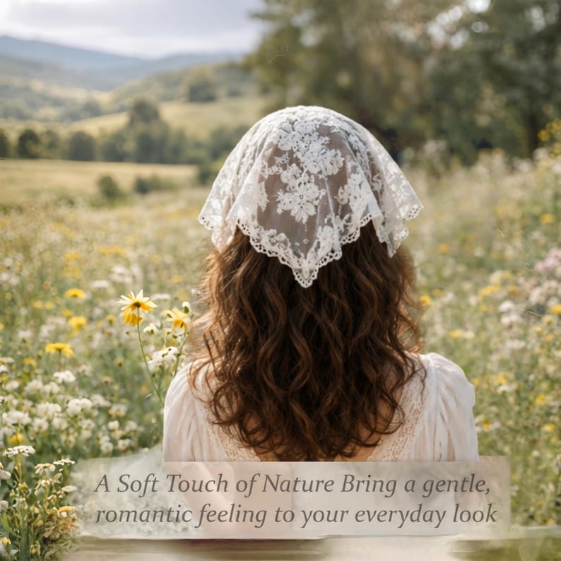 May include: A white lace head covering with floral patterns. The head covering is worn by a person with long, wavy brown hair. The background is a field of wildflowers and a distant view of rolling hills.