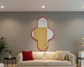 May include: A contemporary living room with a cream sofa, a red-framed mirror, and a white rug. The room has a neutral colour scheme, with green plants and a bust sculpture, creating a stylish and inviting space.