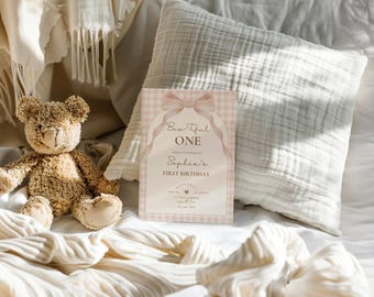 May include: A pink and white gingham patterned invitation with a pink bow and the text "Beautiful One" and "Sophia's First Birthday".