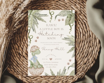 Op de afbeelding: Een babyshower-uitnodiging met een groene dinosaurus die uit een ei komt. De uitnodiging heeft een aquarel achtergrond met groene bladeren en de tekst "RAWR! A LITTLE BOY IS Hatching SOON". De uitnodiging bevat ook de datum, tijd en het adres van de babyshower.
