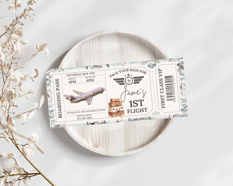 May include: A blue and white airplane ticket invitation with the text "Boarding Pass" and "Pack Your Bags For Jame's 1st Flight". The ticket has a vintage design with a small airplane, suitcases, and a barcode.