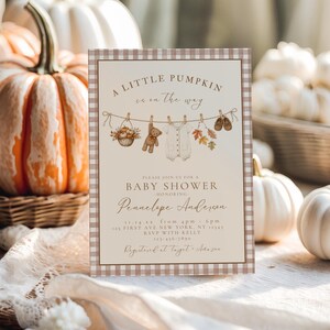May include: A rectangular baby shower invitation card with a brown and white gingham border. The text reads A LITTLE PUMPKIN is on the way, BABY SHOWER, honoring Pennelope Anderson, 11-14-xx, 4pm-6pm, 123 FIRST AVE NEW YORK, NY 12345, RSVP WITH KELLY 123-456-7890, Registered at Target + Amazon.