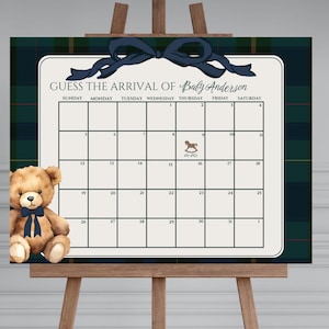May include: A baby shower guessing game sign with a calendar grid, a navy blue bow, and a teddy bear. The sign reads "GUESS THE ARRIVAL OF Baby Anderson" and includes a calendar grid for guests to write their guesses. The background has a plaid pattern.
