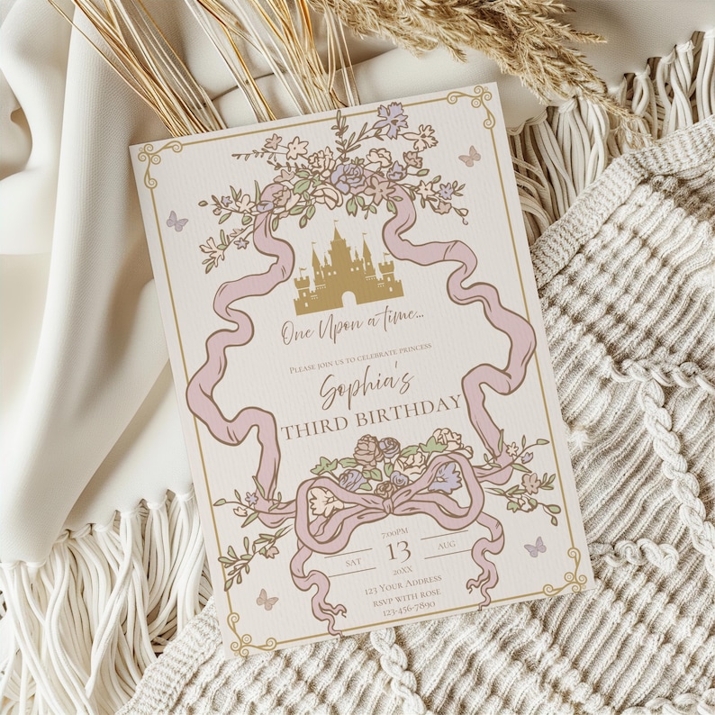 K&ouml;nnte beinhalten: Eine cremefarbene Einladung mit M&auml;rchenmotiv. Das Design zeigt ein goldenes Schloss, rosa B&auml;nder, florale Akzente und den Text "One Upon a time..." und "Sophia's Third Birthday". Schmetterlinge und dekorative Bord&uuml;ren runden das Design ab.