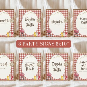 May include: Eight party signs, each with a red and white checkered background and a wooden frame. The signs have various text, including "Favors," "Books & Gifts," "Drinks," and "Diaper Raffle." Each sign features a barbecue grill illustration and is 8x10 inches.
