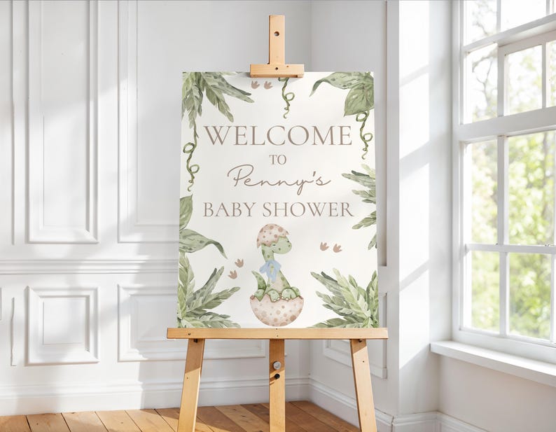 Peut inclure: Panneau d'accueil pour la baby shower de Penny avec une illustration de dinosaure vert et un feuillage vert.