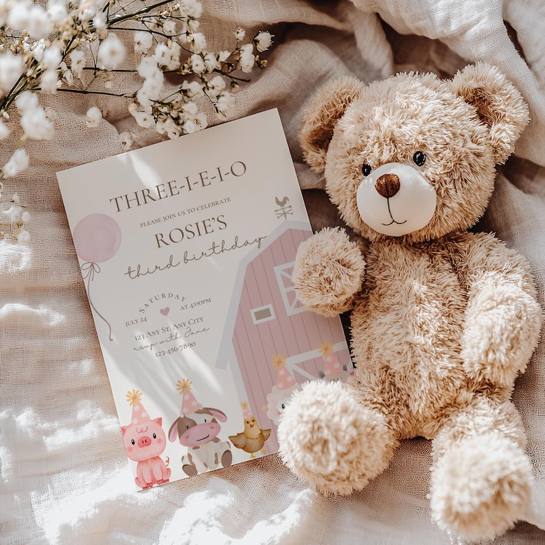 K&ouml;nnte beinhalten: Eine rosafarbene und wei&szlig;e Geburtstagseinladung mit einem Teddyb&auml;r darauf. Die Einladung lautet "Three-I-E-I-O" und "Rosie's third birthday". Die Einladung enth&auml;lt auch eine Farm-Szene mit einem Stall, Tieren und einem Ballon.