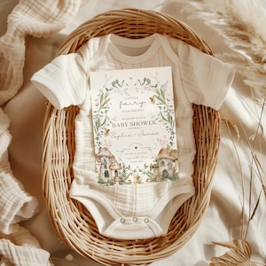 Pu&ograve; includere: Un invito a una baby shower con un tema fatato incantevole. L'invito presenta un'illustrazione ad acquerello di una casetta delle fate, fiori e un'ape. Il testo recita "Una piccola fata &egrave; in arrivo. Unisciti a noi per una baby shower in onore di Sophia e James."