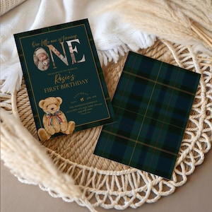 Puede incluir: Invitaci&oacute;n de primer cumplea&ntilde;os verde oscuro con detalles dorados. La invitaci&oacute;n presenta una foto, la palabra "ONE" y una ilustraci&oacute;n de oso de peluche. El reverso de la invitaci&oacute;n tiene un patr&oacute;n de cuadros verdes. La invitaci&oacute;n est&aacute; sobre una superficie tejida.