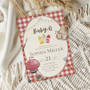 Op de afbeelding: Een rood-wit geblokte babyborrel uitnodiging met een cartoon illustratie van een barbecue, kruiden en een schort. De tekst luidt "Baby-Q" en "Sophia Miller".