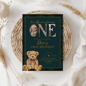 Puede incluir: Una invitaci&oacute;n de cumplea&ntilde;os verde oscuro y dorada con una ilustraci&oacute;n de oso de peluche. La invitaci&oacute;n dice "Our little one is turning ONE" con una foto de beb&eacute;. Tambi&eacute;n se incluye el texto "Rosie's First Birthday".