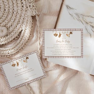 May include: Two rectangular cards with a light brown gingham border. The top card features a clothesline illustration with baby items and the text Books For Baby. The bottom card features a similar clothesline illustration and the text Diaper Raffle.
