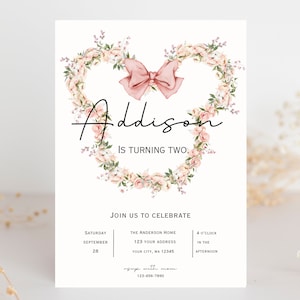 Op de afbeelding: Een roze bloemenkrans met een roze strik in het midden, met de naam "Addison" en de tekst "Is turning two." De uitnodiging bevat ook details voor een verjaardagsfeest, inclusief de datum, tijd en locatie.