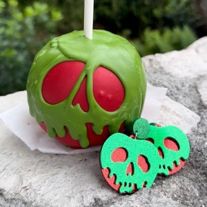 May include: A green and red candy apple with a skull design, and a pair of green and red skull-shaped earrings.