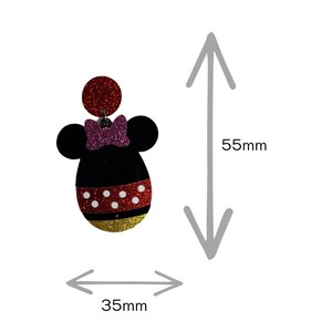 Op de afbeelding: Rode, zwarte en witte glitter Minnie Mouse oorbel met een roze strik. De oorbel is 5,5 cm hoog en 3,5 cm breed.