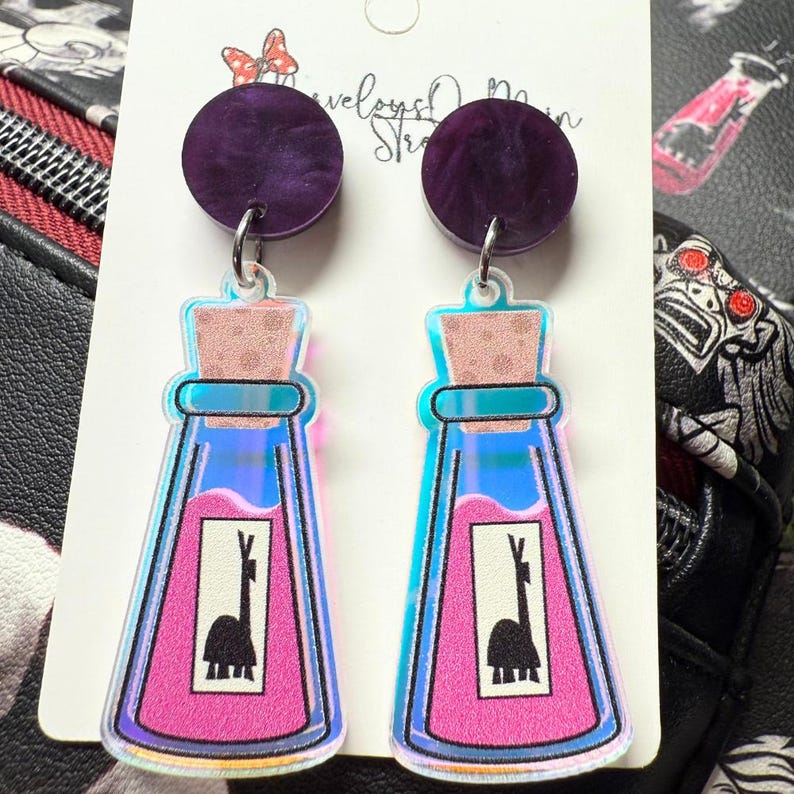 picture of dangle drop earrings featuring the poison bottle from the Disney movie the emperors new groove.