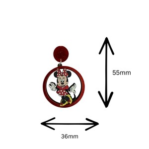 K&ouml;nnte beinhalten: Rote Minnie Mouse-Ohrringe. Die Ohrringe haben eine rote Glitzerspitze, einen roten kreisf&ouml;rmigen Rahmen und eine Minnie Mouse-Figur. Die Ohrringe messen 5,5 cm in der H&ouml;he und 3,6 cm in der Breite.