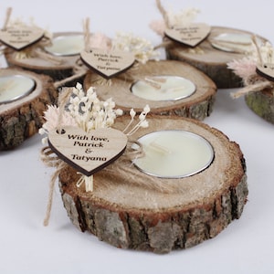 May include: Rustic wooden candle holders with small white candles, decorated with dried flowers and a heart-shaped tag that says "With love, Patrick & Tatyana".