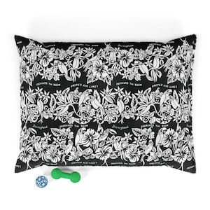 May include: Black and white pillow with a tropical print featuring birds, flowers, and the text "Enchanted Tiki Room", "Disneyland", and "United Air Lines".