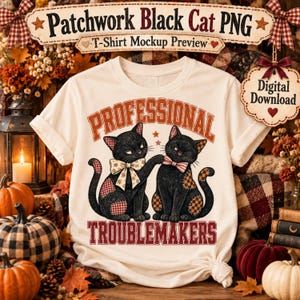May include: A cream-colored t-shirt featuring a graphic of two black cats with patchwork patterns, wearing bows, and the text "PROFESSIONAL TROUBLEMAKERS" in a red collegiate font. The design includes small stars and a decorative border.